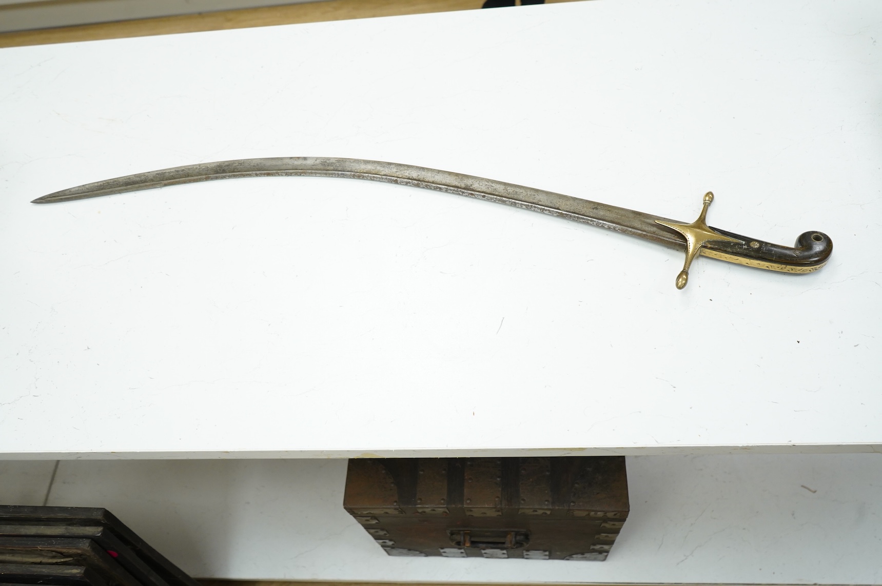 An Ottoman sword kilij with rounded back edge, traces of gold cartouche to the blade, brass cross piece, and two-piece horn grip, blade approximately 76cm